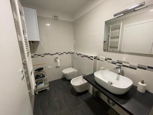 a white bathroom with a sink and a toilet at Apartment Tartini in Piran