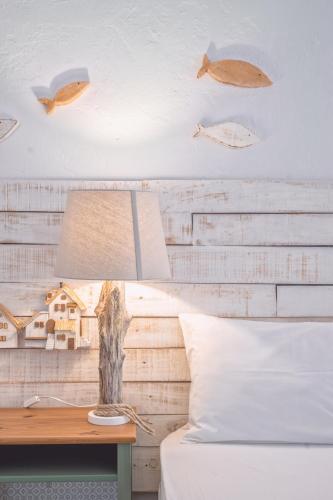 a lamp on a table next to a bed at Brunis Apartments in Nei Poroi