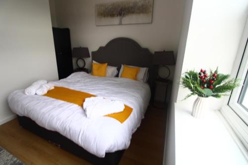 a bedroom with a bed with white sheets and a window at Flat 316 Beautiful one bed flat in Birmingham