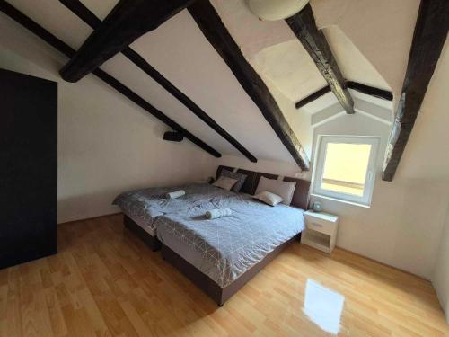 a bedroom with a bed in a room with wooden floors at Vila Antik in Ilirska Bistrica