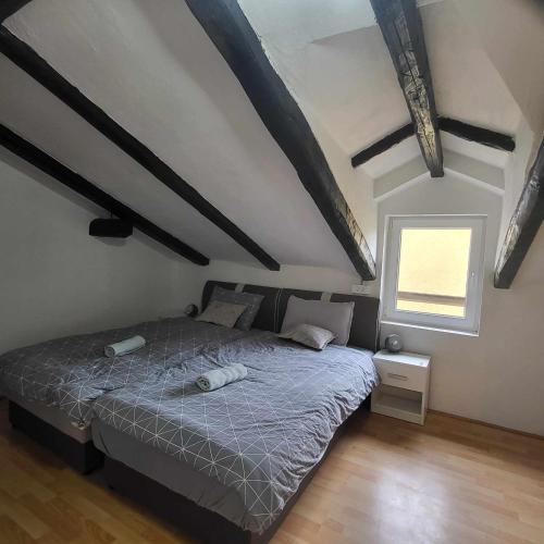 a bedroom with a bed in a room with wooden floors at Vila Antik in Ilirska Bistrica