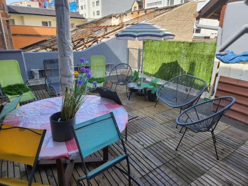 un patio avec une table et des chaises sur une terrasse dans l'établissement Les Cigognes d'Alsace, à Colmar