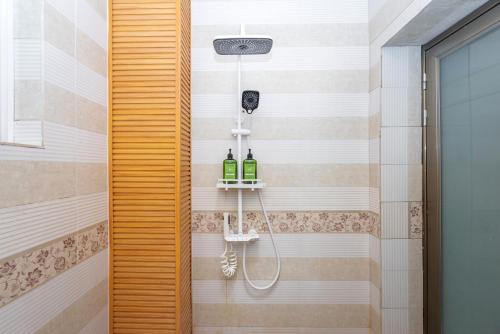 a bathroom with a shower with two bottles of wine at 渔月撸猫客栈-大理古城店 in Dali