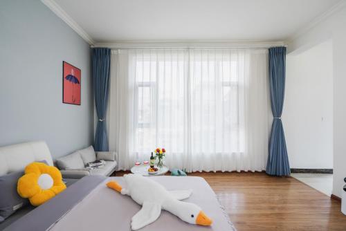 a bedroom with a bed with a stuffed animal on it at 渔月撸猫客栈-大理古城店 in Dali