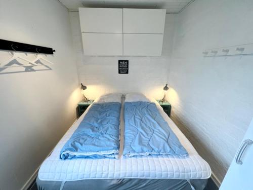 a bed in a small room with two lamps at Agger Tange Feriecenter lejligheder - 100 m fra Vesterhavet in Vestervig