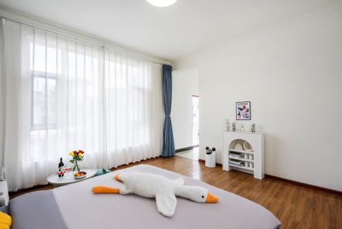 a bedroom with a bed with a stuffed animal on the floor at 渔月撸猫客栈-大理古城店 in Dali