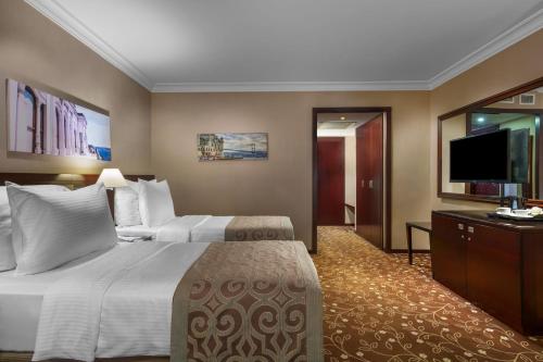 a hotel room with a bed and a flat screen tv at Kaya İstanbul Fair & Convention in Istanbul