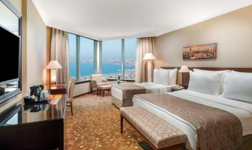 a hotel room with two beds and a large window at Kaya İstanbul Fair & Convention in Istanbul