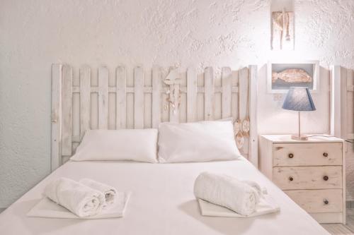 a bedroom with a white bed with towels on it at Brunis Apartments in Nei Poroi