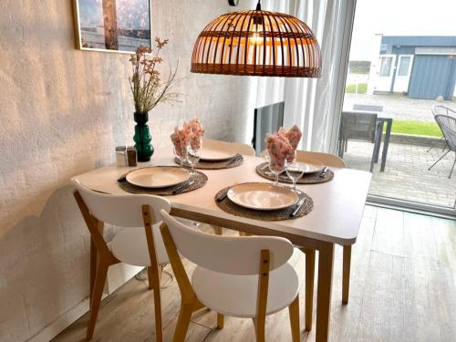 a dining room table with two chairs and a lamp at Agger Tange Feriecenter lejligheder - 100 m fra Vesterhavet in Vestervig