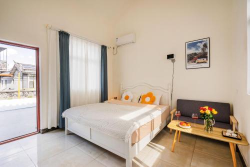 a bedroom with a bed and a table with flowers on it at 渔月撸猫客栈-大理古城店 in Dali