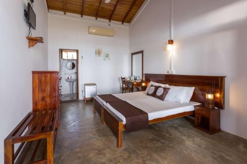 a bedroom with a large bed and a table at Pearl Oceanic Resort - Trincomalee in Trincomalee