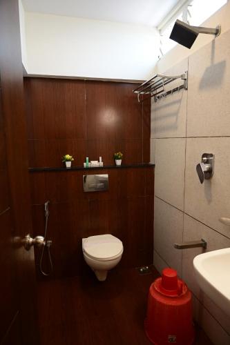 a bathroom with a toilet and a sink and a light at Canyon sun in Chennai