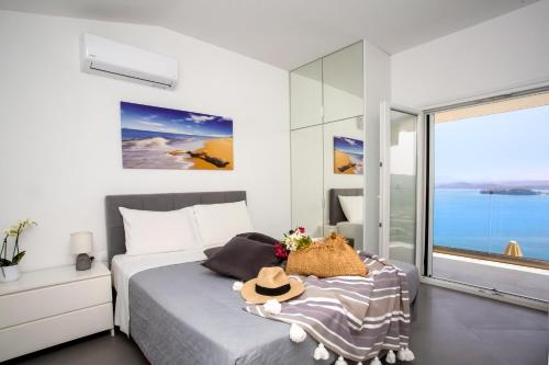 a bedroom with a bed and a large window at N&L VILLAS in Pyrgi