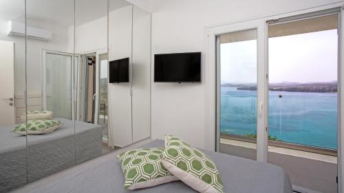 a bedroom with a bed and a view of the water at N&L VILLAS in Pyrgi