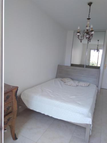 - une chambre avec un lit avec un miroir et une table dans l'établissement Plein soleil et plage, à Fréjus