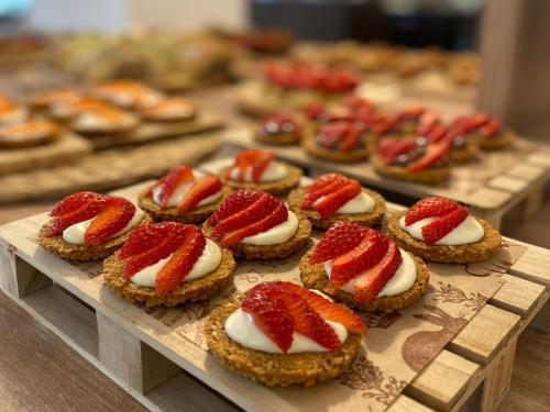 a bunch of deserts with strawberries on top on a table at Hotel Bianca Vela in Rimini
