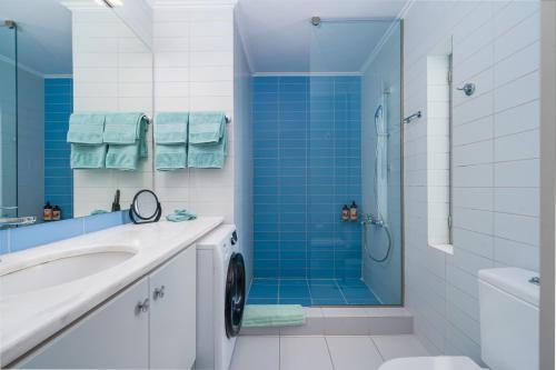 Vouliagmeni - Apollonos Street في أثينا: حمام مع حوض استحمام ودش