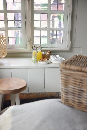 eine Küchentheke mit einem Tisch und einem Korb sowie Fenster in der Unterkunft Huis met de Kogel in Alkmaar