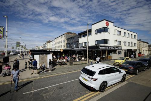 Un coche blanco estacionado al costado de una calle de la ciudad. en Haven heights international, en Blackpool