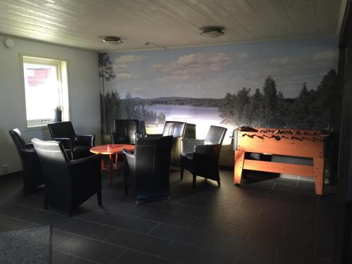 a dining room with chairs and a table and a painting at Piteå Golfhotell in Piteå
