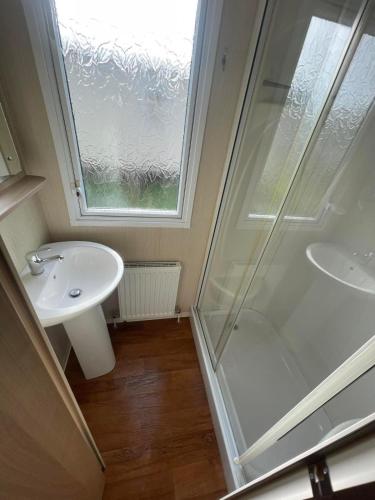 a bathroom with a shower and a sink at Lyons robin hood caravan 43SW in Rhyl