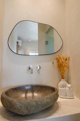 a bathroom with a large stone sink and a mirror at Sea sound in Mylopotas