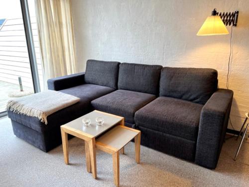 a living room with a couch and a coffee table at Agger Tange Feriecenter lejligheder - 100 m fra Vesterhavet in Vestervig