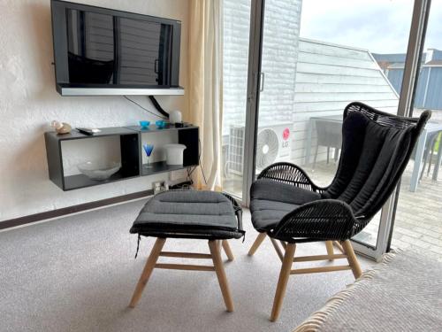 a living room with two chairs and a television at Agger Tange Feriecenter lejligheder - 100 m fra Vesterhavet in Vestervig