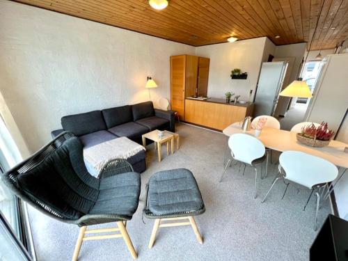 a living room with a couch and a table and chairs at Agger Tange Feriecenter lejligheder - 100 m fra Vesterhavet in Vestervig
