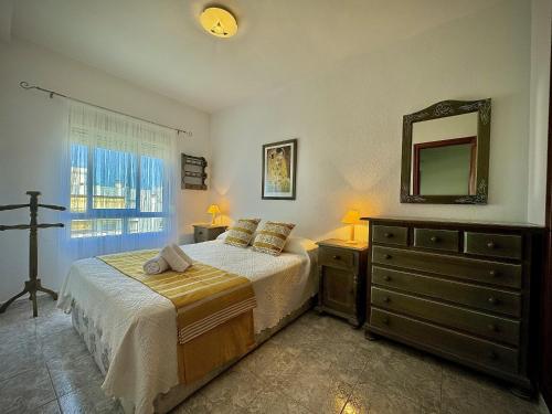 ein Schlafzimmer mit einem Bett mit einer Kommode und einem Spiegel in der Unterkunft Marbella Central 5 by Homing in Marbella