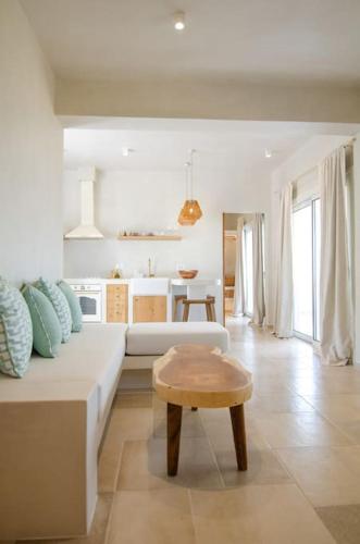 a living room with a white couch and a table at Sea sound in Mylopotas