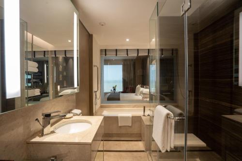 a bathroom with a sink and a shower and a tub at Sheraton New Delhi Hotel in New Delhi