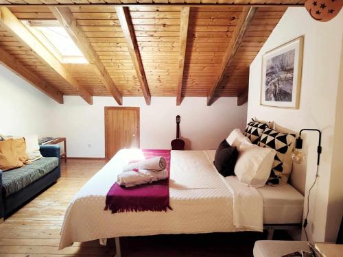 a bedroom with a large bed in a room with wooden ceilings at Homestay Attic Private Bedroom in Aljezur