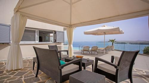 a patio with a table and chairs and an umbrella at N&L VILLAS in Pyrgi