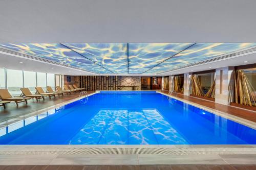 a large swimming pool with blue water in a building at Kaya İstanbul Fair & Convention in Istanbul