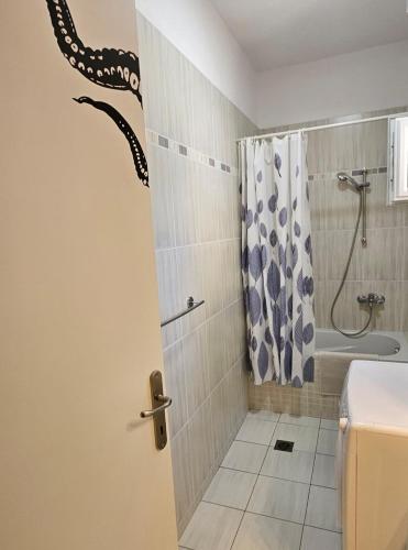 a bathroom with a shower with a snake on the wall at KRAKEN Apartment in Leptokarya