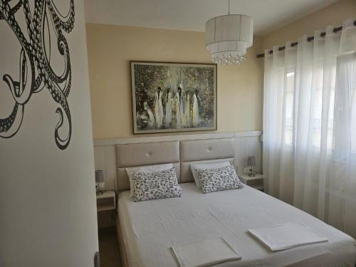 a bedroom with a white bed with two pillows at KRAKEN Apartment in Leptokarya