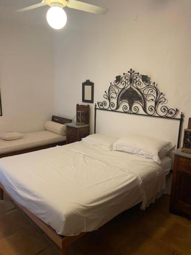 een slaapkamer met een groot wit bed met een hoofdeinde bij Villa Bianca, piscina e panorama in Torre delle Stelle