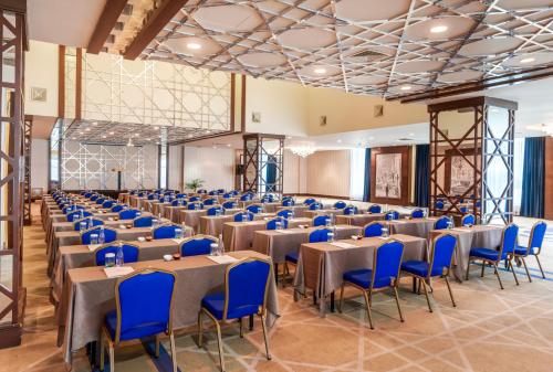a large banquet hall with tables and blue chairs at Kaya İstanbul Fair & Convention in Istanbul