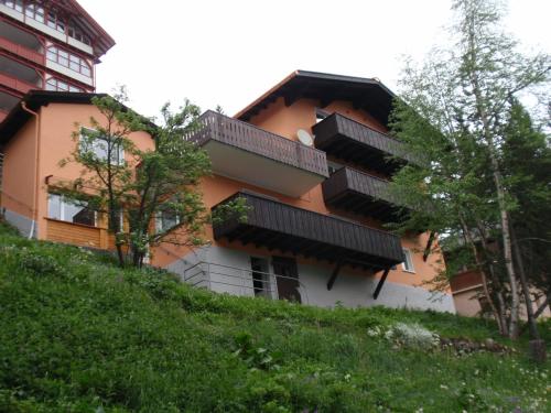 ein Gebäude mit Balkonen an der Seite eines Hügels in der Unterkunft Chalet Tannenrain & Casa Alba in Arosa