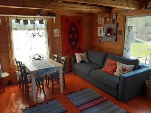 ein Wohnzimmer mit einem Sofa und einem Tisch in der Unterkunft Leppälän vanhatupa rantasaunalla in Utsjoki