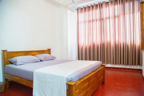 a bedroom with a bed and a large window at SkyAvenue Guest House in Kadawatha