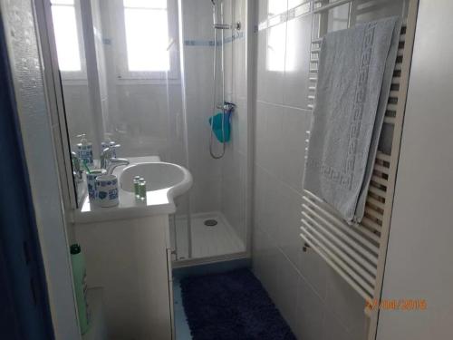 a white bathroom with a sink and a shower at Maison confortable à Saint-Hilaire-de-Riez avec jardin clôturé in Saint-Hilaire-de-Riez
