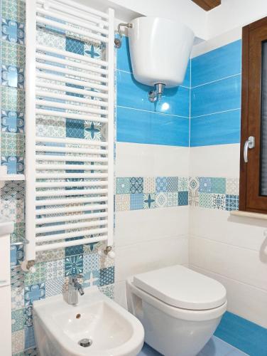 a blue and white bathroom with a toilet and a sink at Residenza Degli Dei in Tropea