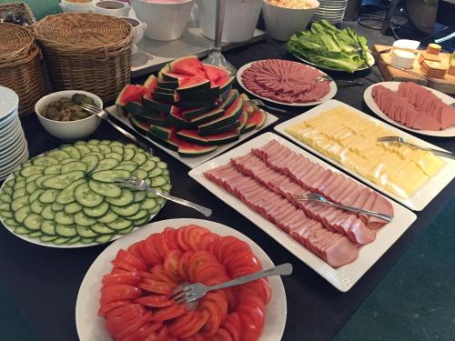 a table with different types of food on plates at Piteå Golfhotell in Piteå