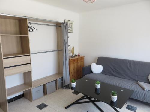 un salon avec un canapé et une table dans l'établissement Le Géranium, à Port-la-Nouvelle