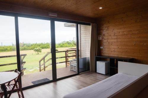 a bedroom with a large window and a balcony at PenichePraia - Bungalows, Campers & SPA in Peniche