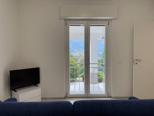 a living room with a blue couch and a large window at Luxury Apartment LUNA in Moltrasio