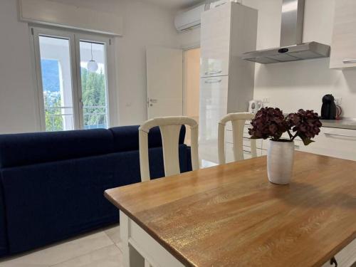 a living room with a blue couch and a table with flowers at Luxury Apartment LUNA in Moltrasio